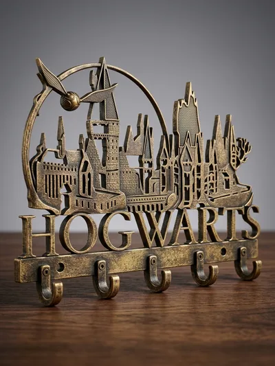 Věšák s hradem, nápisem Hogwarts a háčky ve zlatavém provedení